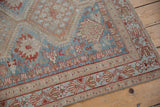 Distressed vintage Afshar rug corner showing even wear, geometric motifs, and intact selvage.