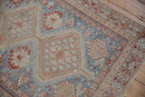 Distressed vintage Afshar rug showing muted blue, madder red, and ivory stylized patterns.