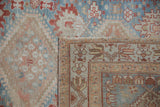 Worn pile of a distressed vintage Afshar rug corner with madder root geometric border.