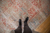 Vintage distressed Karaja rug texture, featuring faded cherry red, pale blue, and ivory geometric motifs.