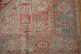 Detail of distressed Karaja carpet with faded cherry red, pale blue geometric patterns.