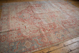 Distressed Karaja rug's worn geometric patterns in faded cherry red, powder blue, and ivory.