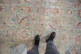 Distressed Khorassan carpet field with powder blue, blush, and ivory palmettes showing wear.