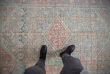 A personal view looking down at the distressed, geometric patterns of a vintage Mahal rug.