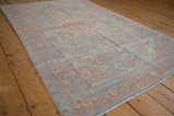 Vintage Mahal rug from an angle, showing its time-softened powder blue and ruby red patterns.