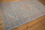 Angled view of a vintage Mahal rug's distressed medallion on a powder blue field.