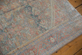 Angled view highlighting the time-softened colors and worn texture of a vintage Mahal rug.
