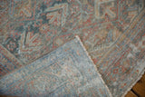 A folded corner of the vintage Mahal rug reveals its hand-knotted back and distressed, low pile.
