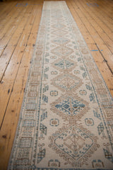 Distressed vintage Northwest Persian runner showing hook and latch motif and interconnected geometric medallions.