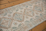 Distressed vintage Persian rug detail: softened ivory, coffee brown, and denim blue medallion pattern.