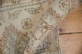 Distressed pile texture with ivory, coffee, and denim blue hook and latch motifs.