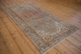 Distressed Borchalou rug corner, showing sky blue and rust Herati patterns with intact side cord.