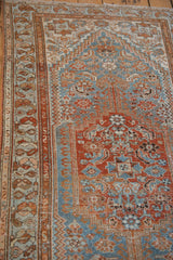 Distressed vintage Borchalou rug detail showing worn sky blue, madder root, and beige geometric motifs.
