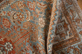 Vintage Distressed Borchalou rug folded, showcasing worn geometric patterns, sky blue, rust, and beige.