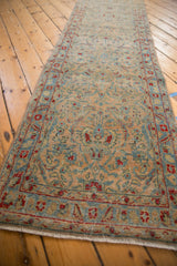Angled view of a distressed Sarouk runner showing directional blossoms in powder blue and cherry red.