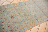 Angled view of a vintage Sarouk runner showing its distressed texture and directional pattern.