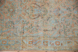 Distressed texture of a vintage Sarouk runner's low pile showing blush and blue tones worn to the foundation.