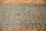 Distressed texture of a vintage Sarouk runner with powder blue and cherry red floral details.