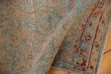 Hand-knotted texture and even wear on a distressed Sarouk rug, folded to show the border.