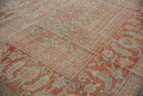 Distressed terracotta and powder blue Herati pattern detail on a vintage Mahal carpet corner.