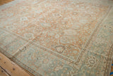 Distressed vintage Mahal carpet corner: terracotta field, powder blue border, floral motifs.