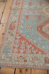 Distressed powder blue and red vintage Caucasian rug with geometric motifs and even wear.