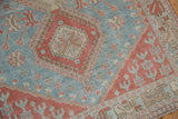 Distressed Caucasian rug's powder blue and pale cherry red geometric motifs, showing even pile wear.