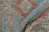 Distressed powder blue and cherry red geometric motifs on vintage Caucasian rug.
