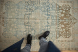 Distressed vintage Malayer rug with faded powder blue field and coffee brown blossomed shrubs.