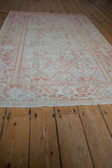 Low angle view of a vintage Mahal rug with repeating geometric patterns in faded terracotta and seafoam.