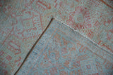 Folded corner of a vintage Mahal rug showing the hand-knotted back and low pile texture.