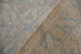 Distressed pile of the vintage Malayer rug: faded ivory field and coffee border design.