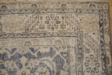 Distressed Sparta rug corner, worn ivory Herati field, dusty navy serrated floral border.