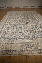 Distressed Sparta carpet close-up, dusty navy Herati motif and serrated leaf border.