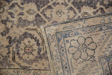 Worn Herati pattern on dusty navy and ivory pile, revealing the hand-knotted foundation.