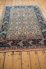 Curvilinear navy border with pink blossoms on the distressed Bijar rug's geometric field.
