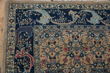Corner detail of distressed Bijar rug, highlighting navy curvilinear floral border and beige geometric Herati field.