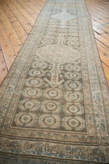 Distressed vintage Malayer runner with geometric Herati pattern in time-softened beige and blue tones.