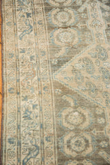 Distressed Malayer runner close-up showing worn pile with pale blue geometric Herati design.