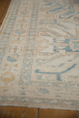 Worn pile texture on a distressed Karaja runner, featuring beige and light blue geometric patterns.