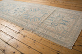 Distressed vintage Karaja runner pile with even wear, muted blue and beige geometric patterns.