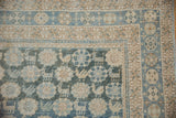 Distressed vintage Mahal rug corner with sky blue, beige borders, faded animal and floral patterns.