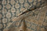 Folded corner of distressed Vintage Mahal carpet, showing worn texture, dusty blue and beige borders.