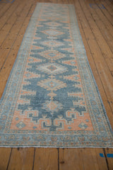 Distressed vintage Malayer runner, repeating geometric medallions in faded dusty blue and pale terracotta.