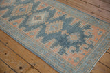 Close-up of vintage Malayer runner's faded blue field and terracotta floral border.