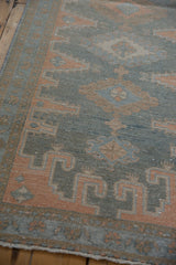 Distressed vintage Malayer runner with muted dusty blue, terracotta geometric and floral patterns.