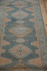 Distressed vintage Malayer runner with terracotta geometric medallions and hook and latch motif.