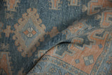 Distressed Malayer rug pile showcasing faded dusty blue and soft pale terracotta hues.