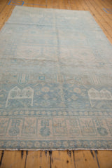 Distressed powder blue and sand geometric border pattern on a vintage Bijar rug runner.