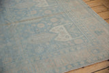 Distressed vintage Bijar rug runner showing muted powder blue and beige floral patterns.